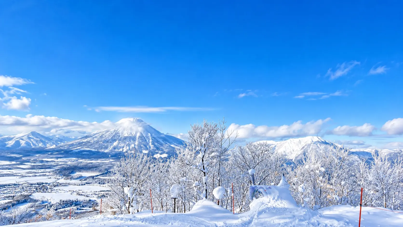 Snow-covered mountains and frosted trees under a blue sky in Hokkaido