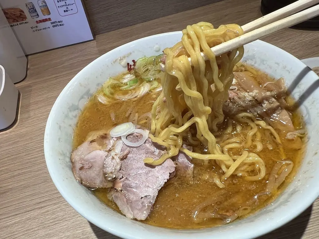 さっぽろ純連：從味噌湯中夾起的黃色麵條