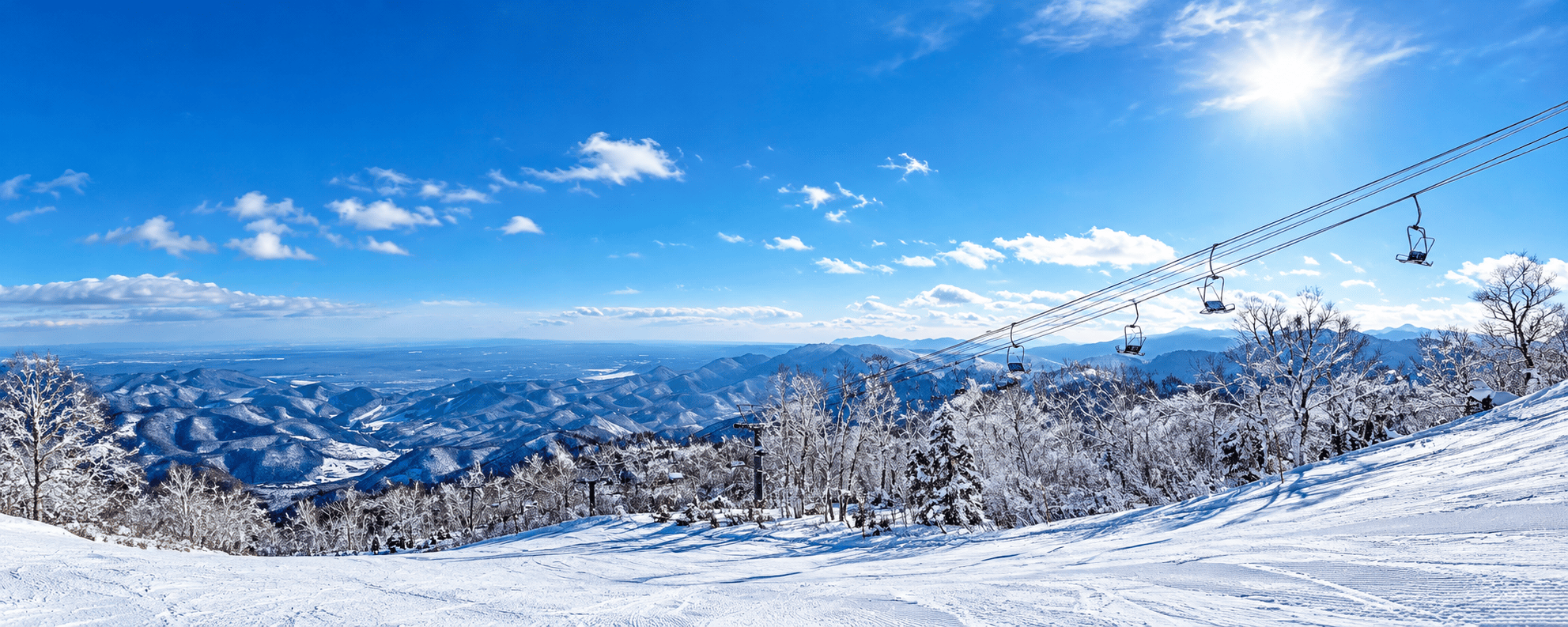 青空の下のゲレンデとリフト、雪山